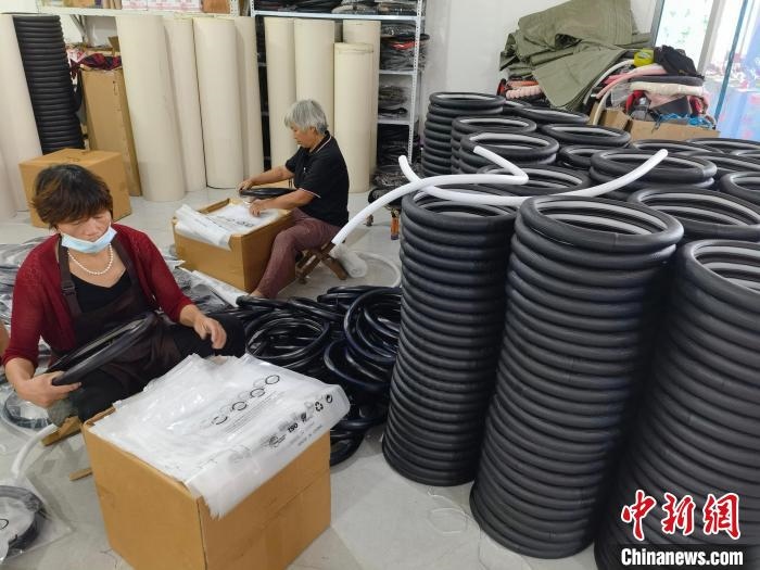 圖為村民在汽車飾品企業(yè)生產(chǎn)車間中工作。　呂子豪 攝