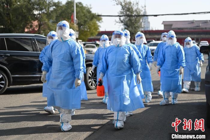 圖為醫(yī)務(wù)人員在封閉小區(qū)做防控工作?！⑽娜A 攝