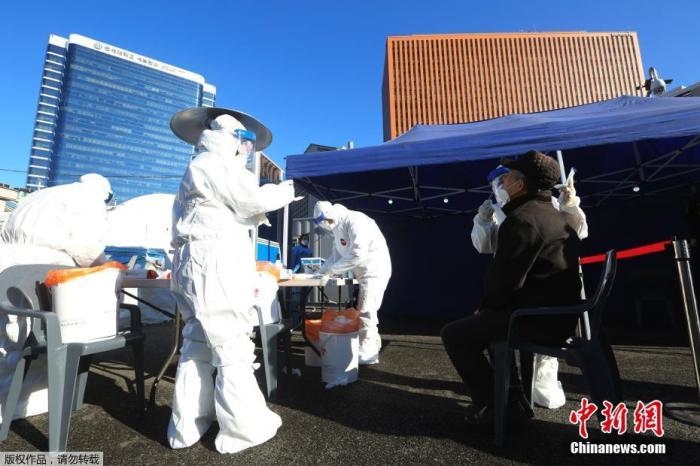 資料圖：韓國(guó)首爾，醫(yī)務(wù)人員對(duì)市民進(jìn)行新冠病毒檢測(cè)。