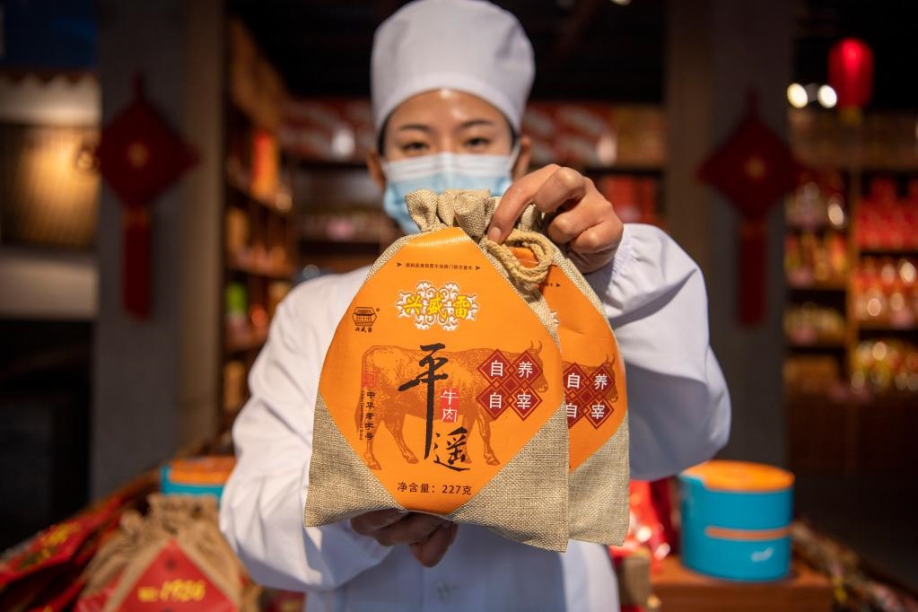 1月27日，在平遙古城南大街的一家平遙牛肉店內(nèi)，工作人員展示一款牛肉產(chǎn)品。新華社記者 楊晨光 攝