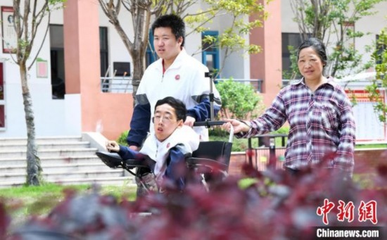 碰上天氣好，朱金祥就會利用休息時間，和鐘華強母親將其推出來賞賞花，曬曬太陽，呼吸一下外面的新鮮空氣。 卓忠偉 攝