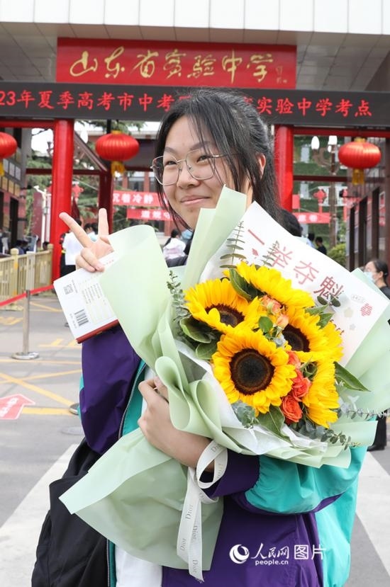 6月7日高考首日，山東67萬(wàn)考生走進(jìn)考場(chǎng)，拼搏逐夢(mèng)。在山東省實(shí)驗(yàn)中學(xué)考點(diǎn)，考生進(jìn)考場(chǎng)前手捧向日葵花拍照留念，寓意“一舉奪魁”。人民網(wǎng)記者 劉祺攝
