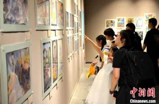 圖為家長(zhǎng)帶著孩子參觀展覽。呂明 攝