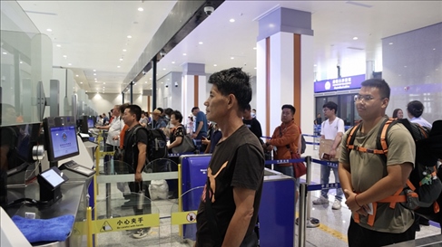 6月13日，乘坐中老鐵路國(guó)際旅客列車的旅客在磨憨邊檢大廳排隊(duì)候檢。李揚(yáng) 攝