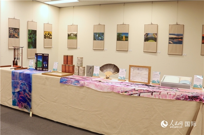 現(xiàn)場(chǎng)展出的馮學(xué)敏攝影作品與湖州市特色工藝品。（人民網(wǎng) 許可攝）