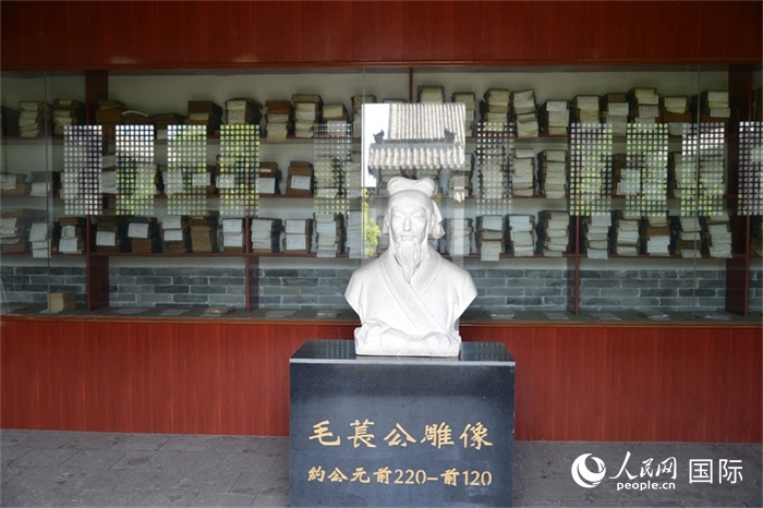 河間詩(shī)經(jīng)齋毛萇雕像。雕像后書櫥中陳列的是歷代各版本《詩(shī)經(jīng)》及譯本。 人民網(wǎng) 趙昭攝