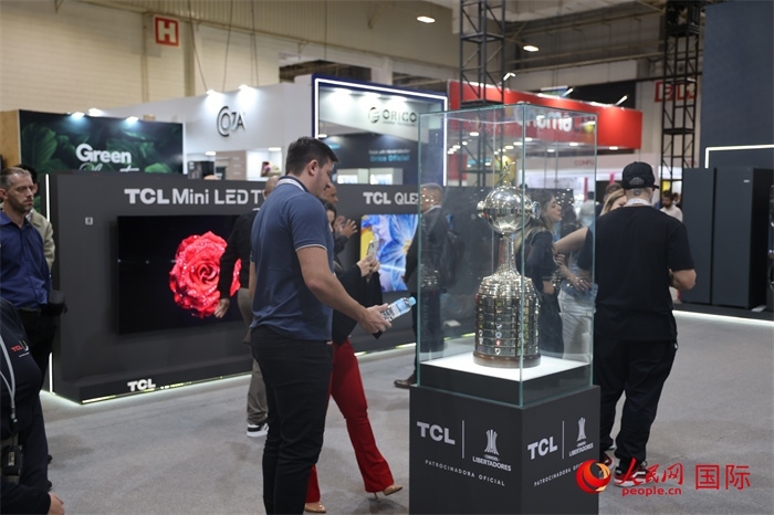 參觀者在TCL展臺(tái)前觀看南美解放者杯獎(jiǎng)杯，據(jù)介紹，TCL是南美解放者杯（2023—2026賽季）全球官方合作伙伴。（人民網(wǎng)記者 時(shí)元皓攝）