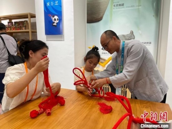 市民體驗(yàn)制作吉祥如意結(jié)。祝歡 攝