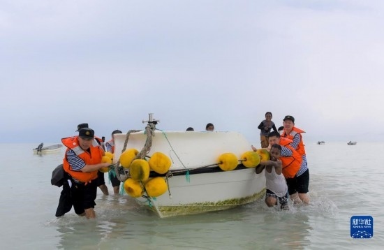 7月21日，中國海軍“和平方舟”號醫(yī)院船醫(yī)護人員涉水登島，前往基里巴斯一診療點。新華社記者 黎云 攝