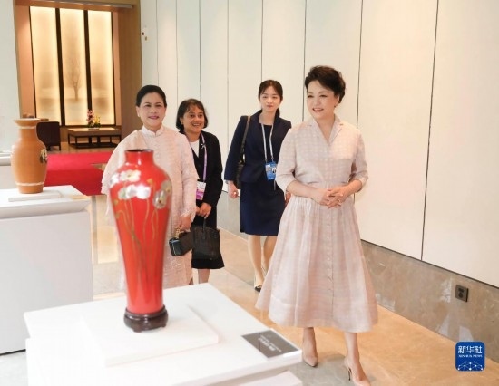 7月27日下午，國家主席習(xí)近平夫人彭麗媛在四川成都會(huì)見陪同印度尼西亞總統(tǒng)佐科來華出席第31屆世界大學(xué)生夏季運(yùn)動(dòng)會(huì)開幕式并訪華的總統(tǒng)夫人伊莉亞娜。這是彭麗媛和伊莉亞娜欣賞成都特色非遺工藝品。新華社記者 丁林 攝