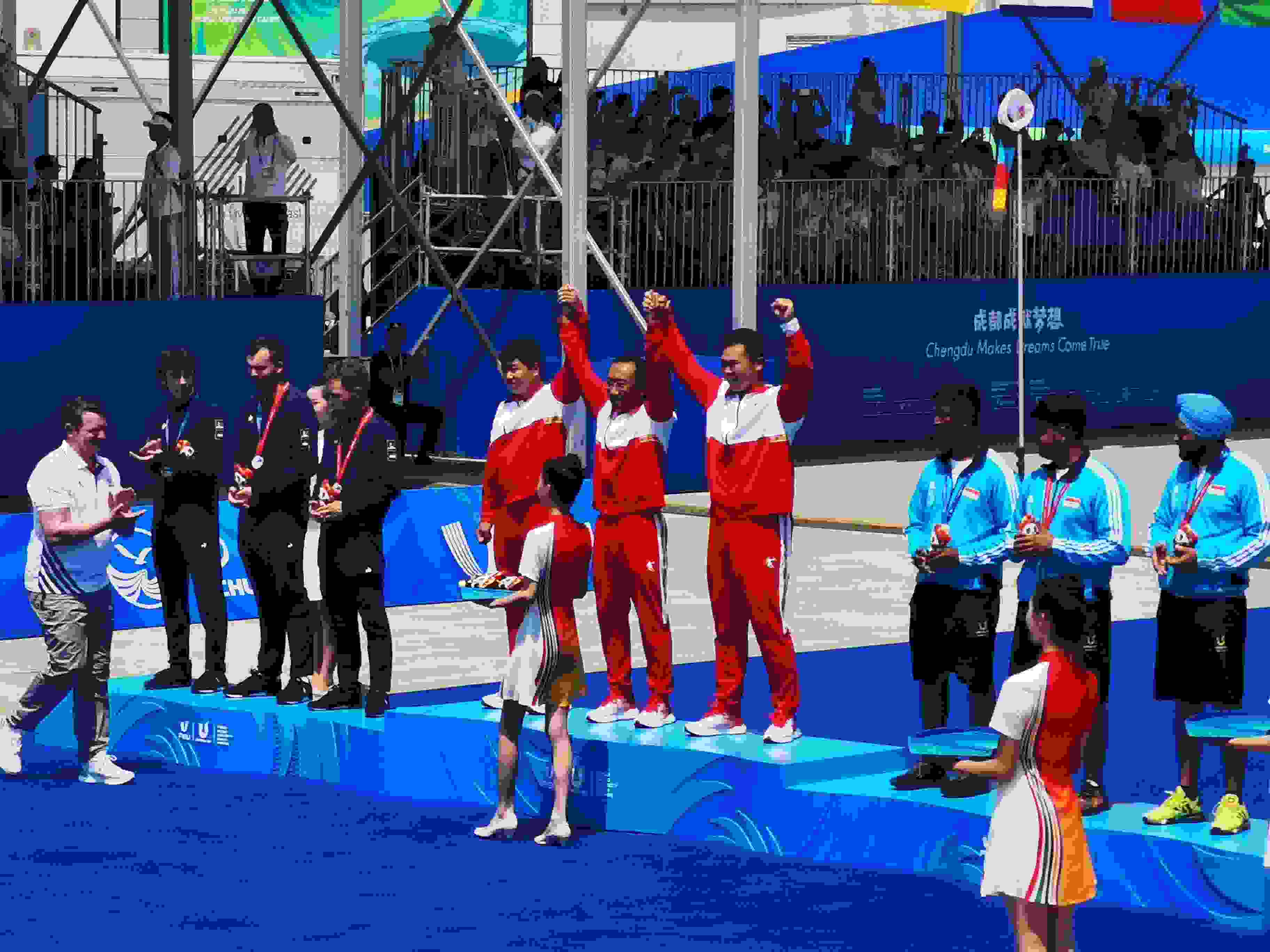 7月30日，在成都大運會男子復(fù)合弓團體頒獎儀式中，中國隊?wèi)c祝奪得冠軍。 人民網(wǎng)記者 楊磊攝