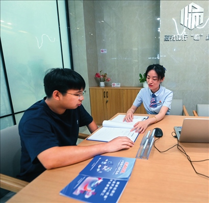 在杭州市臨安區(qū)政務(wù)服務(wù)中心的“為企服務(wù)中心”，黨員志愿者（右）解答企業(yè)主的疑問(wèn)（2023年7月7日攝）。徐昱攝/本刊