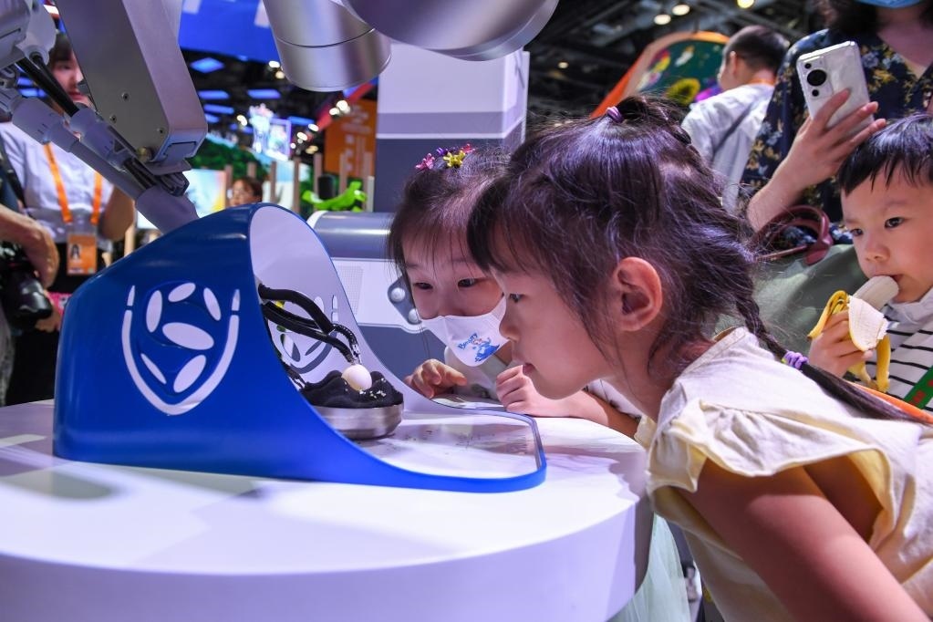 9月3日，幾名小朋友在國(guó)家會(huì)議中心觀看單孔腔鏡手術(shù)機(jī)器人展示。新華社記者 鞠煥宗 攝