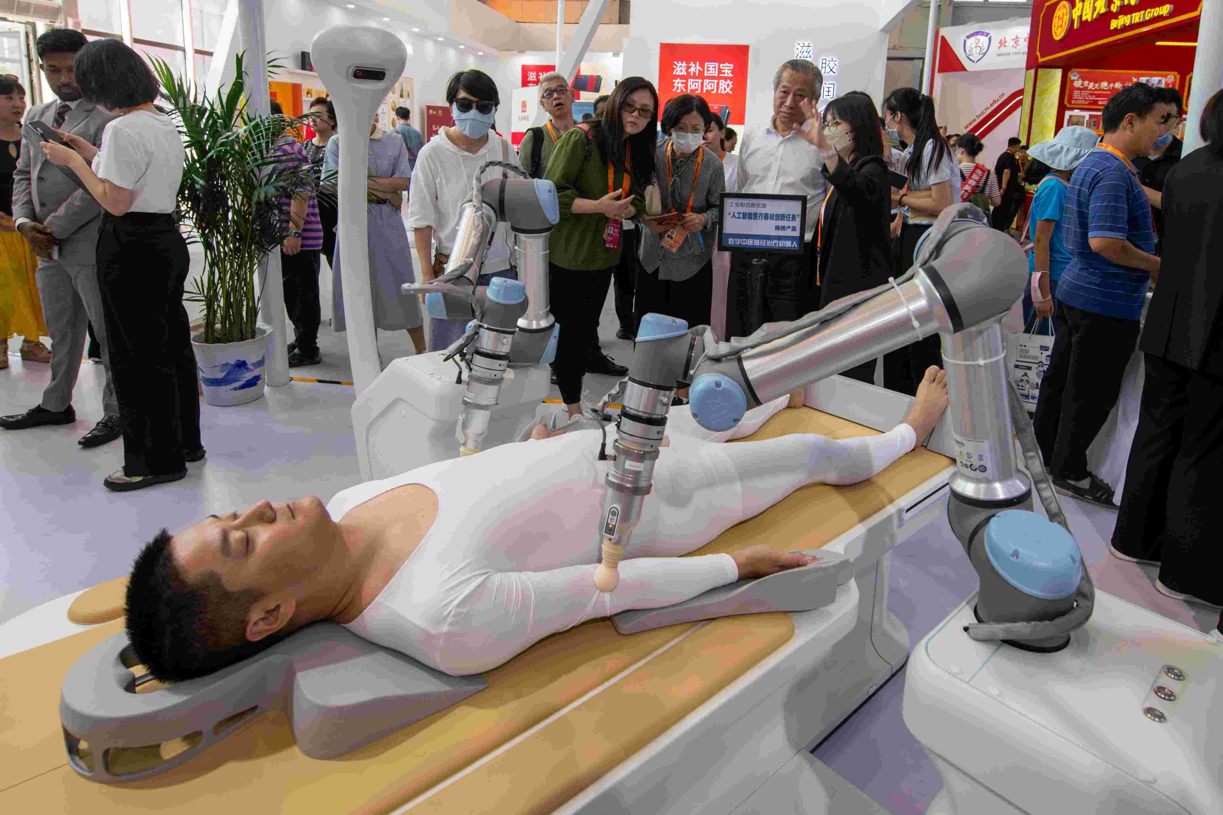 在位于首鋼園的健康衛(wèi)生服務展區(qū)，觀眾正在參觀數(shù)字中醫(yī)循經(jīng)治療機器人。人民網(wǎng)記者 翁奇羽攝