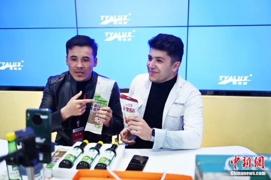 2023年3月，甘肅省慶陽市環(huán)縣電商創(chuàng)業(yè)孵化基地內(nèi)，來自蘭州文理學(xué)院的塔吉克斯坦留學(xué)生正在協(xié)助主播直播帶貨當(dāng)?shù)剞r(nóng)特產(chǎn)品。李亞龍 攝