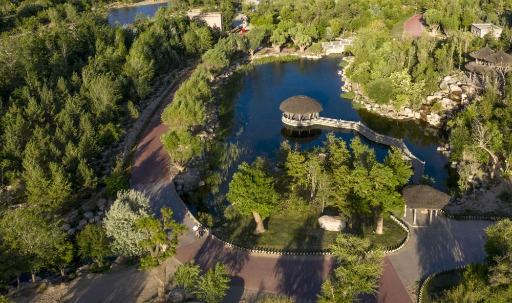 坐落在寧夏銀川市賀蘭山腳下的賀蘭山運動休閑公園（2021年5月27日攝，無人機照片）。這里曾是一片砂石采礦塌陷區(qū)，當(dāng)?shù)赝ㄟ^植被景觀再造、水系建設(shè)、現(xiàn)代管網(wǎng)鋪建等手段，重新利用廢石、廢坑及各類廢棄建筑材料，把這里變成一座免費開放的主題公園。新華社記者 馮開華 攝