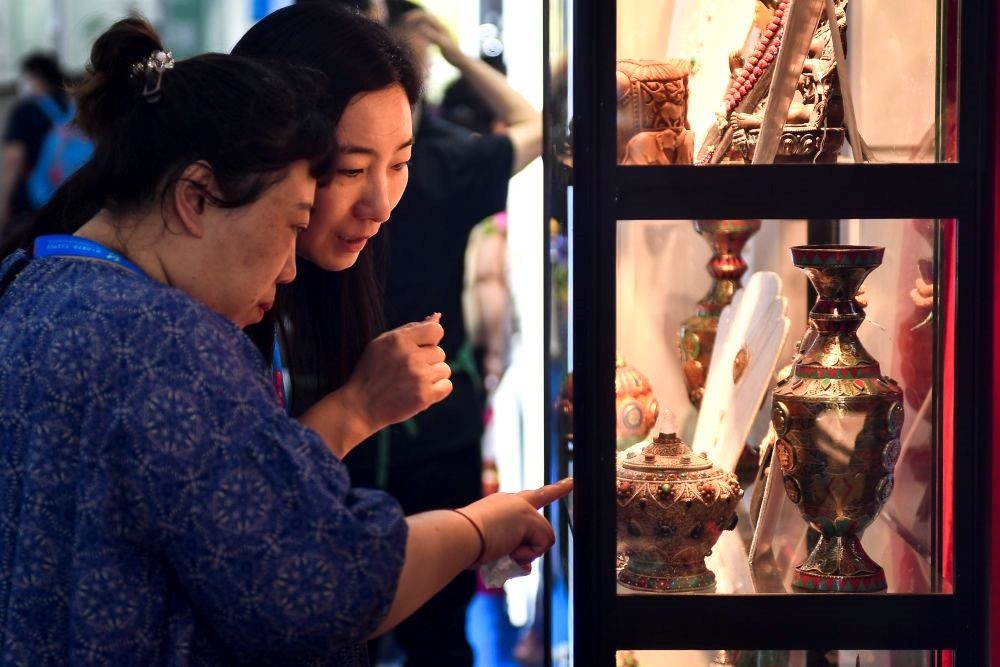 △2023年8月24日，參觀者在第十四屆中國—東北亞博覽會現(xiàn)場選購尼泊爾特色商品。