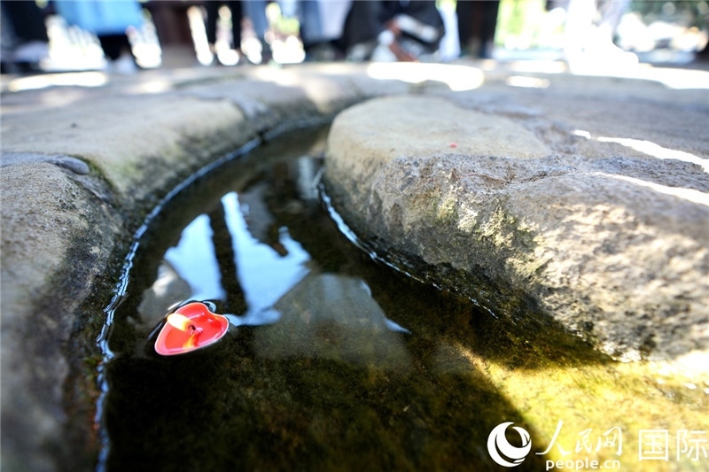 圖為水渠里流過的“桃心”蠟燭。人民網(wǎng) 盧鵬宇攝