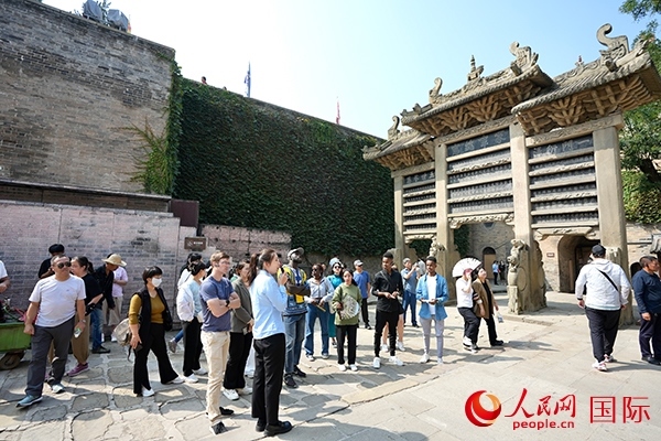 選手們認真聆聽導游講解。人民網(wǎng) 盧鵬宇攝