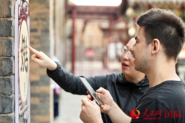 選手安德烈（俄羅斯）在老師指導下學習墻壁上張貼的生僻字。人民網(wǎng) 盧鵬宇攝