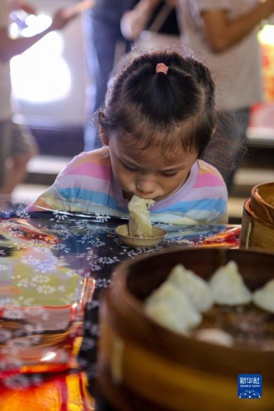 9月27日，小朋友在南翔小籠長(zhǎng)街宴上品嘗南翔小籠。