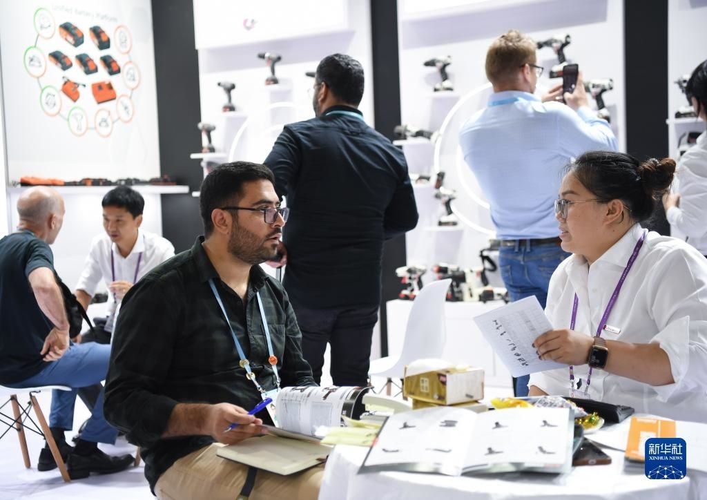 10月15日，在一家電動工具展臺，外國采購商在洽談業(yè)務(wù)。新華社記者 鄧華 攝