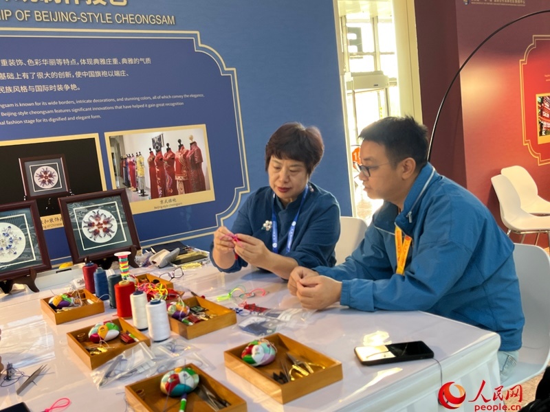 記者在新聞中心非遺傳承人展區(qū)進(jìn)行體驗(yàn)。人民網(wǎng)記者 杜燕飛攝