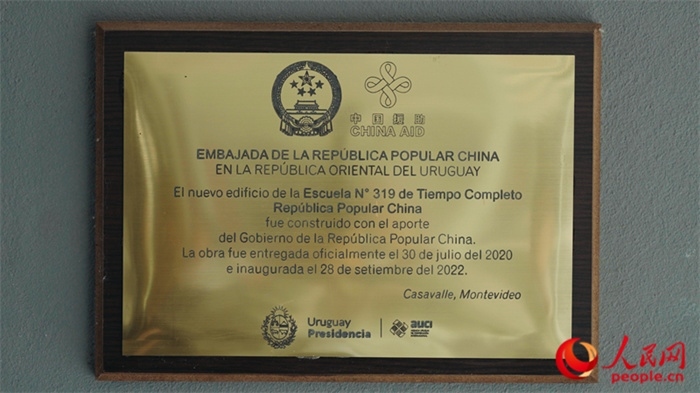 小學墻上懸掛的中國援助標識。人民網(wǎng)記者 張若涵攝