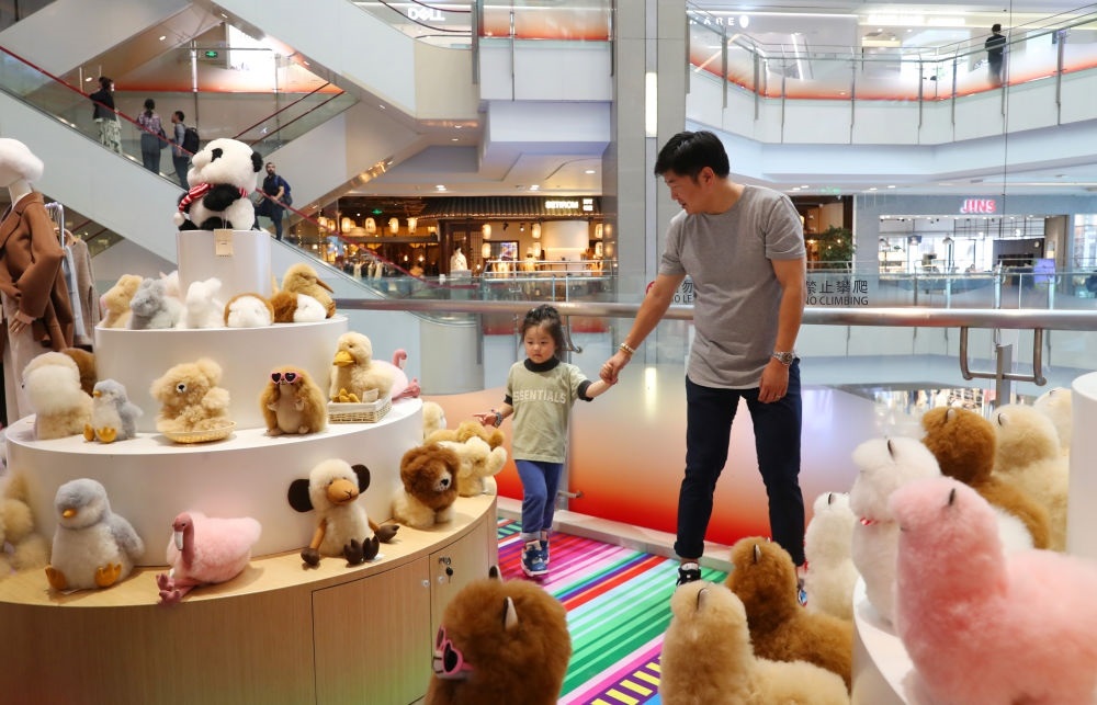 2023年11月2日，顧客在溫暖駝品牌專柜內(nèi)選購。連續(xù)六年參加進博會的秘魯羊駝制品品牌溫暖駝在上海市中心商場開設(shè)了專柜。新華社記者 方喆 攝