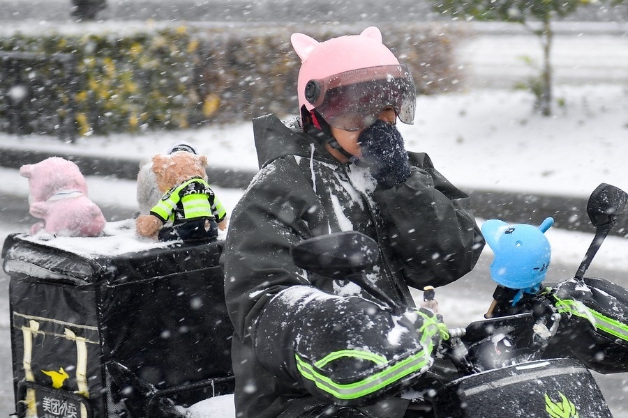 11月6日，在長春市街頭，一名外賣員在雪中騎行。新華社記者 許暢 攝