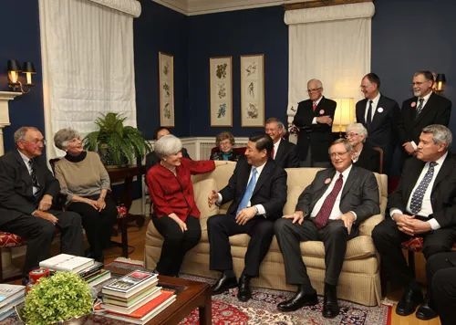 △2012年2月15日，習(xí)近平在前艾奧瓦州友好省州委員會(huì)委員蘭蒂夫人（左三）的家中回憶1985年訪問(wèn)該地時(shí)的情景。