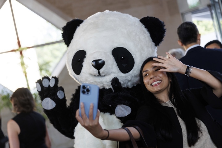 2022年8月24日，在美國華盛頓中國駐美國大使館，來賓與大熊貓玩偶合影。