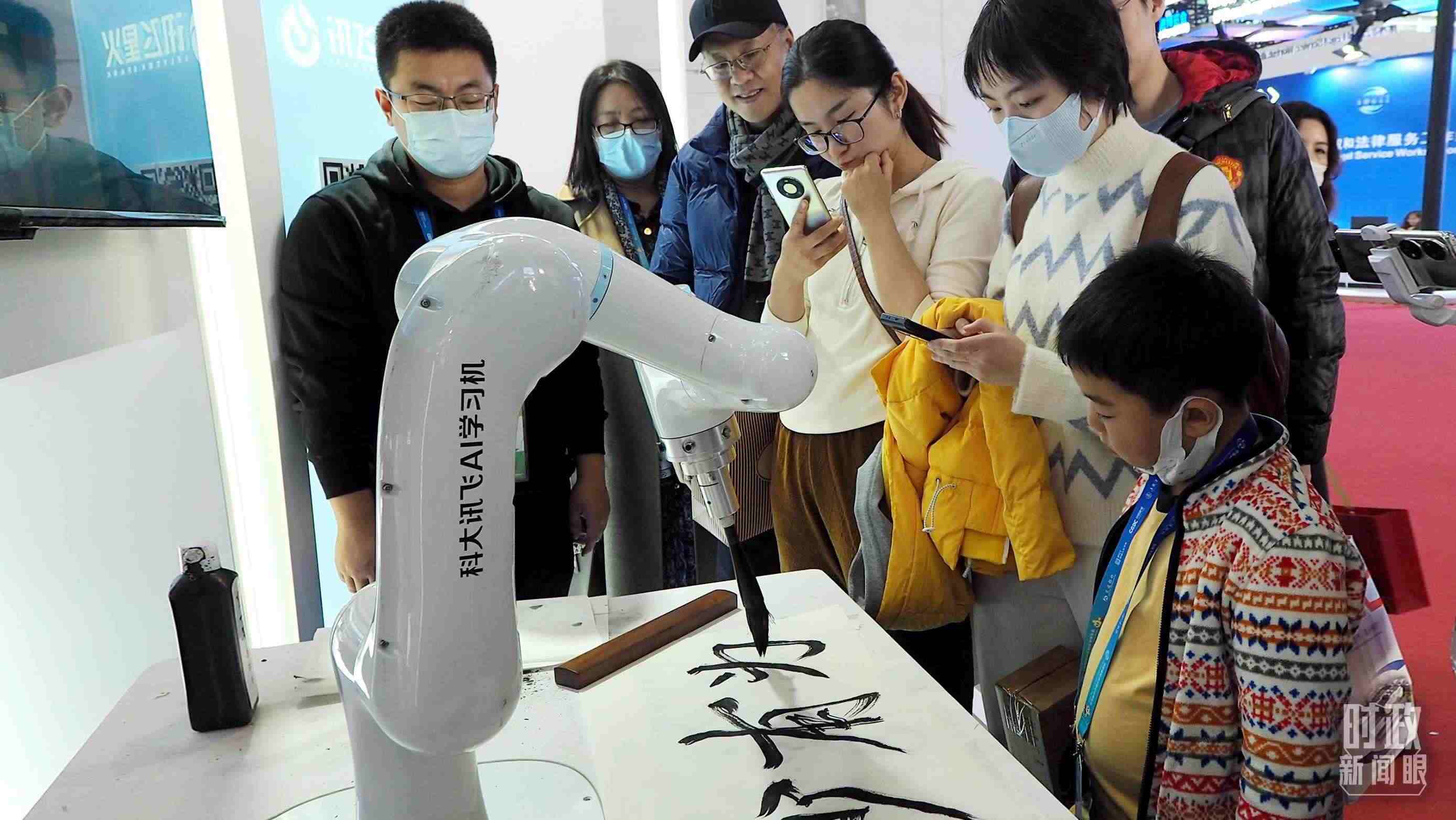 △觀眾在首屆鏈博會上體驗AI書法機器人。