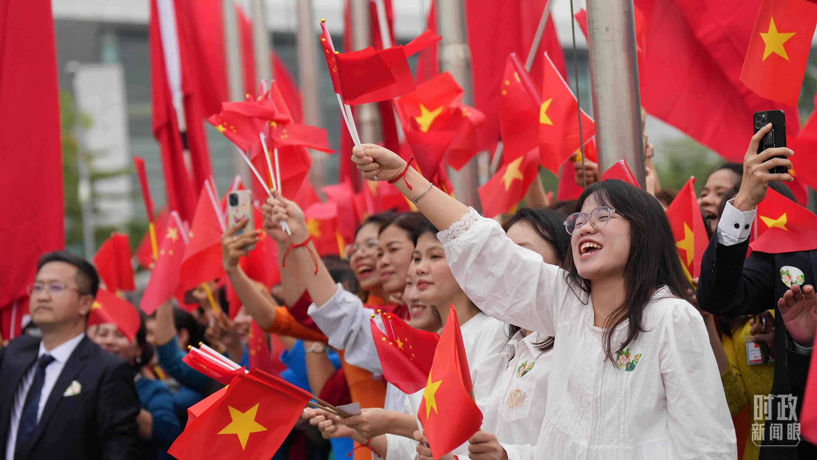 △人們揮舞兩國旗幟歡迎習(xí)近平訪越。（總臺國廣記者李晉拍攝）