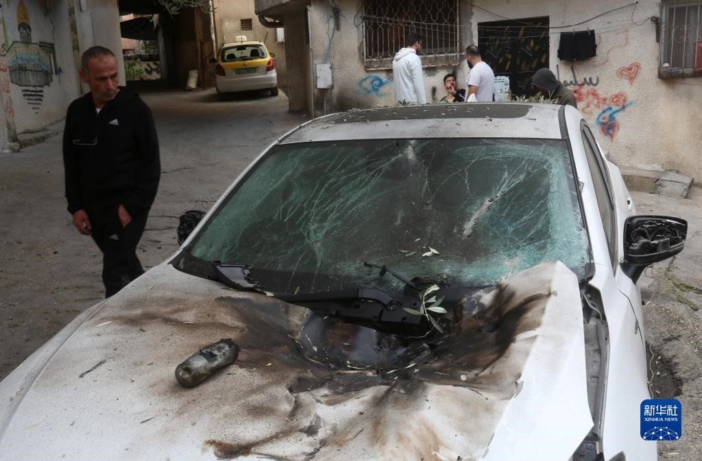 12月17日，在約旦河西岸城市圖勒凱爾姆附近的一處難民營，人們查看在沖突中損毀的車輛。新華社發(fā)（尼達爾·艾仕塔耶攝）