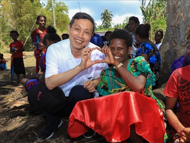 2023年12月18日，中國(guó)駐瓦努阿圖大使李名剛和前來(lái)觀看瓦努阿圖公路項(xiàng)目二期馬勒庫(kù)拉段移交儀式的當(dāng)?shù)鼐用窈嫌?。人民網(wǎng) 賀吉攝