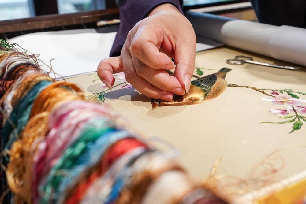 △2023年7月6日，盧建英在江蘇蘇州平江路的工作室內(nèi)刺繡。