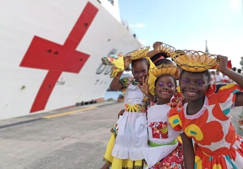 2018年10月，在安提瓜和巴布達首都圣約翰，當(dāng)?shù)匦∨笥焉泶﹤鹘y(tǒng)服裝歡迎中國海軍“和平方舟”醫(yī)院船首次到訪。