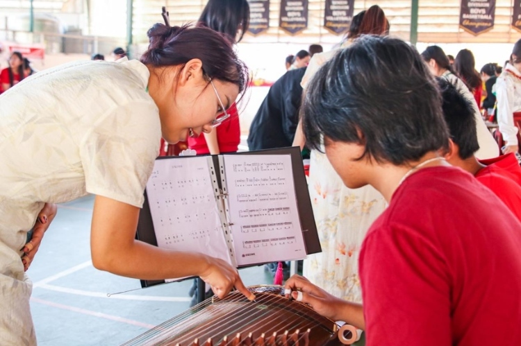 志愿者教師指導(dǎo)學(xué)生彈奏古箏?；顒?dòng)主辦方供圖