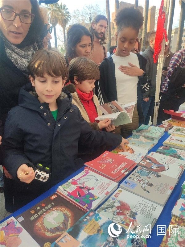 印刷精美的中國傳統(tǒng)文化叢書吸引了小游客的注意。人民網記者鄭彬攝