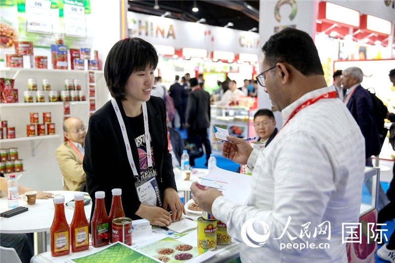 圖為中國參展企業(yè)代表與采購商交流。人民網(wǎng) 塔里克·易卜拉欣攝