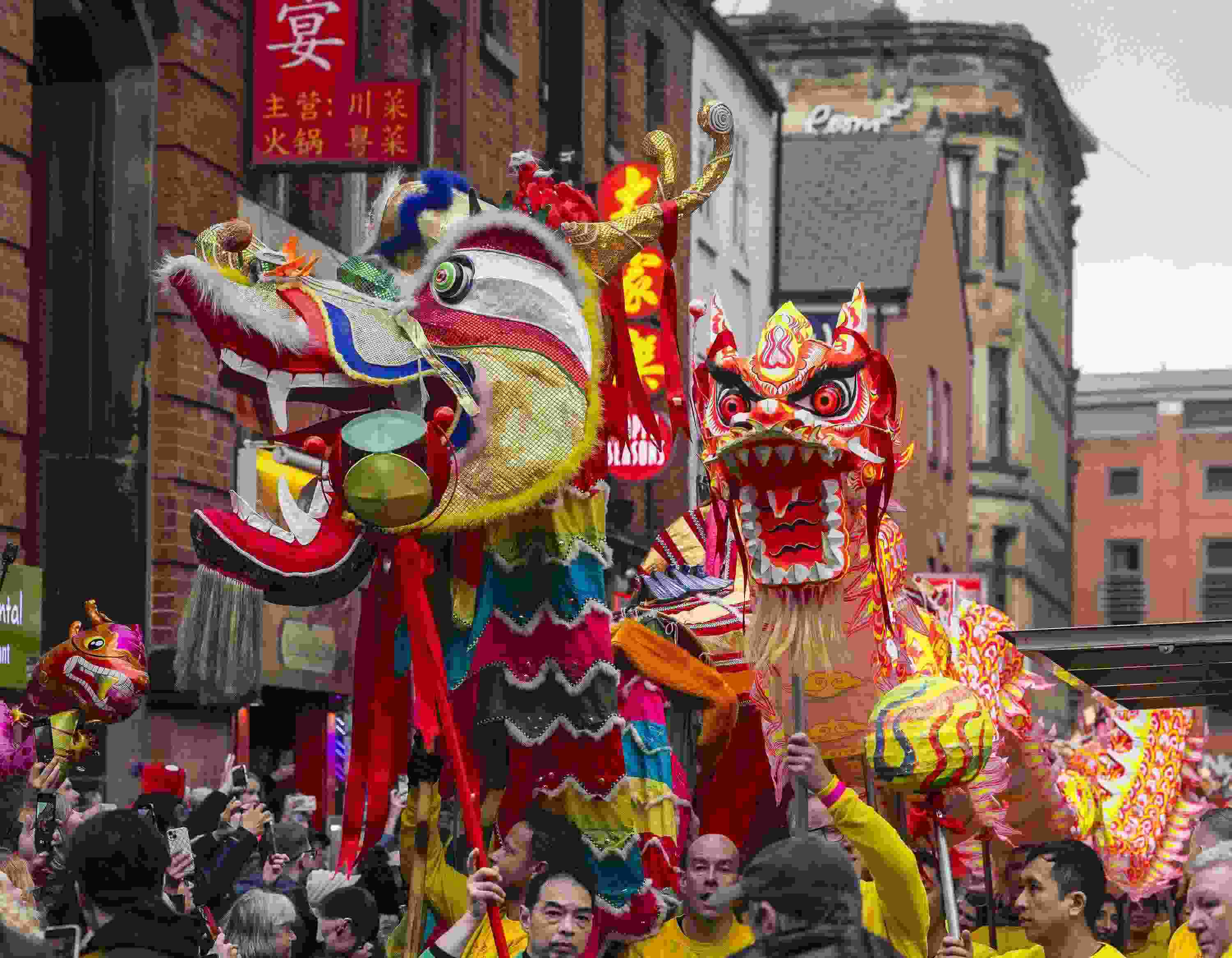 △ 當(dāng)?shù)貢r間2024年2月11日，英國曼徹斯特，表演者進入中國城，參加中國農(nóng)歷龍年春節(jié)的慶?；顒印? width=