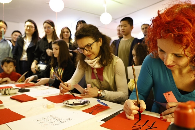 羅馬尼亞觀眾學(xué)習(xí)用毛筆寫“?！弊?。中國文化中心供圖