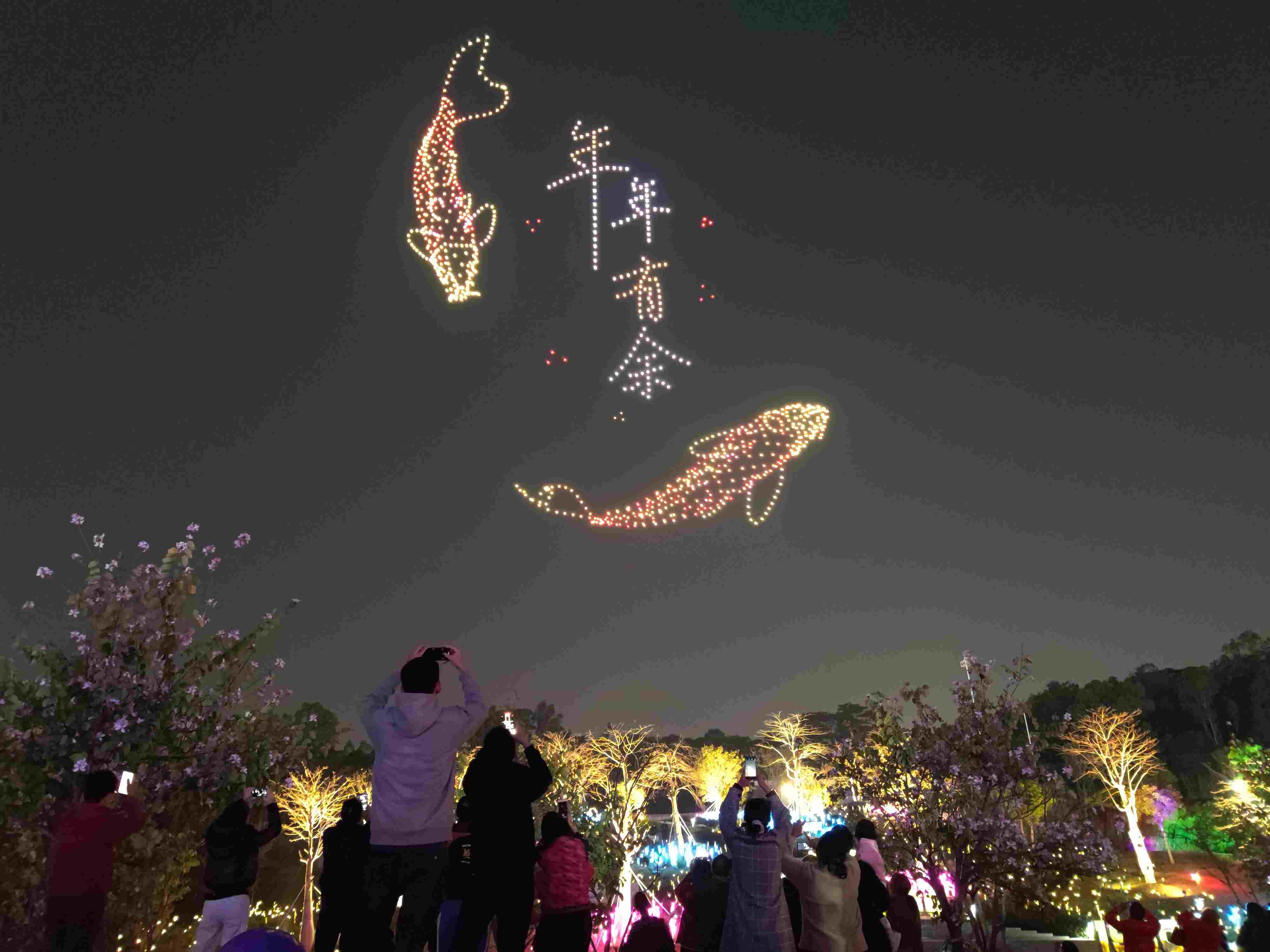 △ 2024年2月10日，深圳北站中心公園，春節(jié)主題無(wú)人機(jī)燈光秀引來(lái)眾多游客駐足觀看。