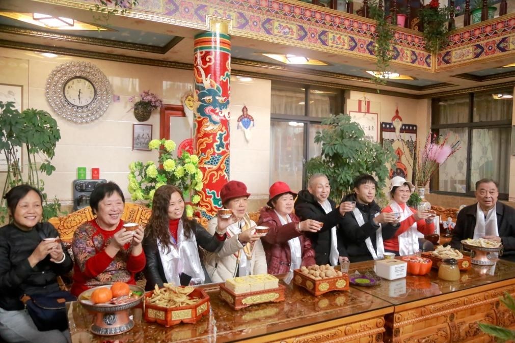 游客們?nèi)胱∶袼藓?，舉杯共飲酥油茶。新華社記者 邱星翔 攝