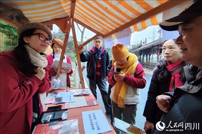 1月6日，“2024成都蒲江柑甜采摘節(jié)”上，記者見到了小萌（左一）和許多年輕人忙著做訪客接待、現(xiàn)場布置、票務核對、采摘服務等工作。人民網(wǎng)記者朱虹攝