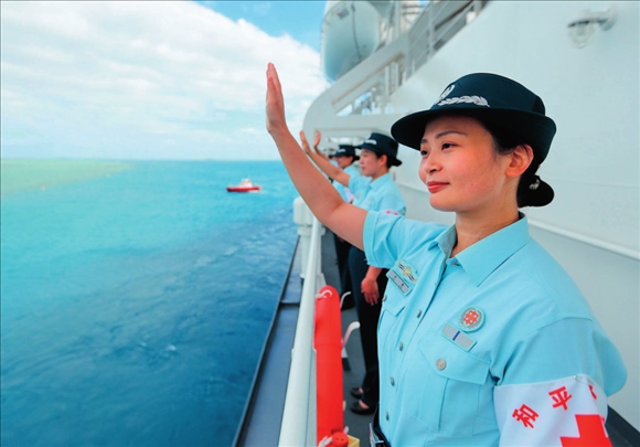 中國海軍“和平方舟”號(hào)醫(yī)院船結(jié)束訪問湯加時(shí)，任務(wù)官兵中的文職人員向歡送人群揮手告別（2023年8月4日攝）。徐巍攝/本刊