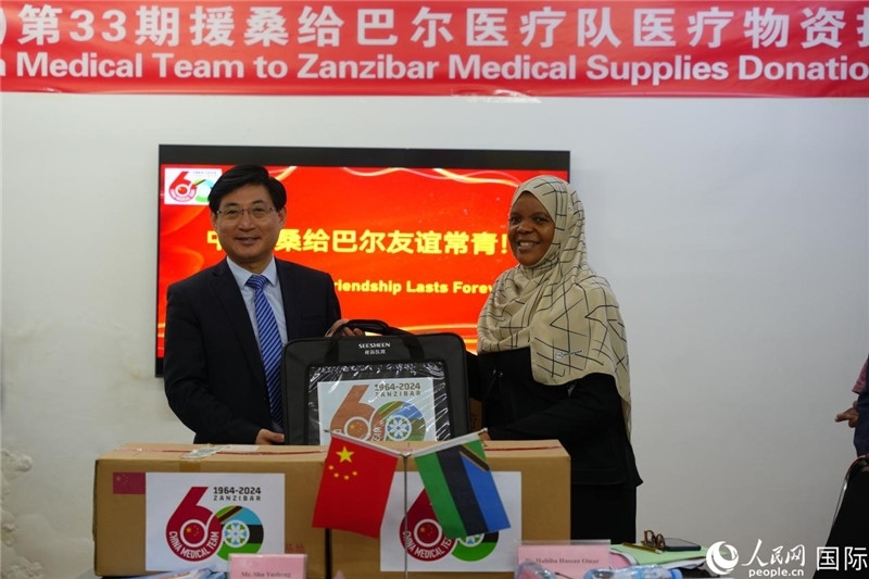 江蘇省蘇北人民醫(yī)院黨委書記束余聲捐贈物資與桑衛(wèi)生部首席秘書哈比巴。中國援桑醫(yī)療隊供圖