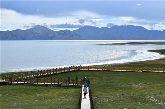 △ 游客行走在青?，敹嗫h冬格措納湖畔的木棧道上。