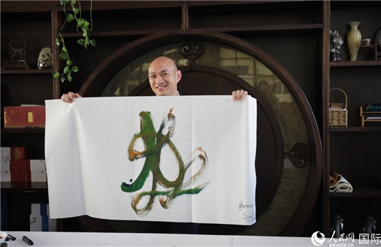 老撾駐華大使館三秘明君參加《五百筆·瀾湄合作》集體藝術(shù)創(chuàng)作。人民網(wǎng)王婧攝。